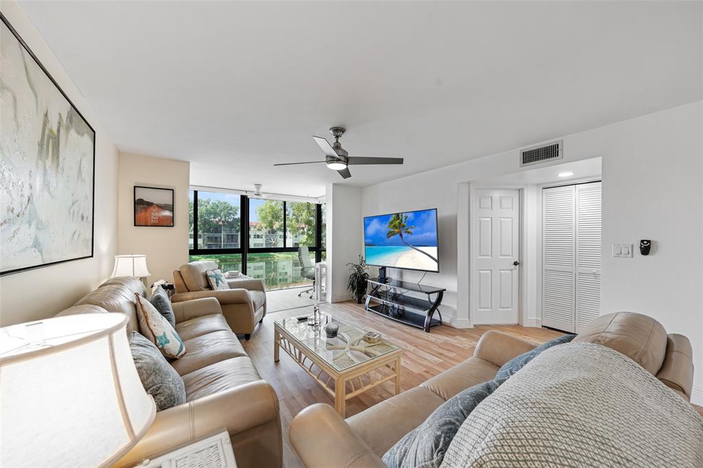 361 South Hollybrook Drive, Unit 201 Pembroke Pines, FL 33025 - Photo 18 of 52 a living room with furniture a ceiling fan and a flat screen tv