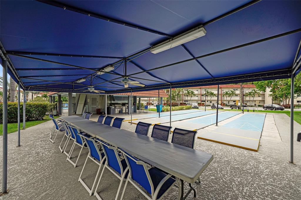 361 South Hollybrook Drive, Unit 201 Pembroke Pines, FL 33025 - Photo 35 of 52 a view of a patio with table and chairs under an umbrella