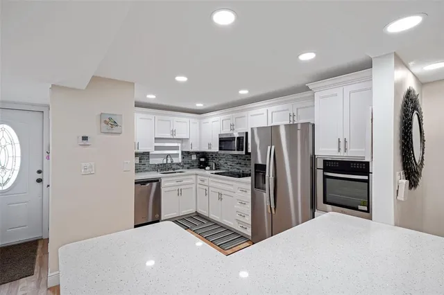 a kitchen with stainless steel appliances a refrigerator sink and stove