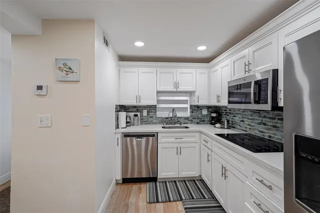 a kitchen with stainless steel appliances a sink stove microwave and cabinets