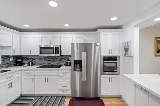 a kitchen with white cabinets and stainless steel appliances