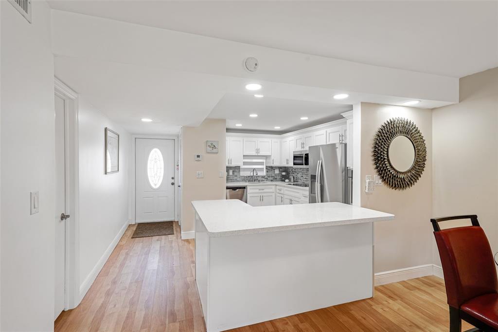 361 South Hollybrook Drive, Unit 201 Pembroke Pines, FL 33025 - Photo 8 of 52 a large kitchen with a wooden floor and white cabinets