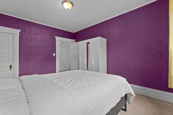 a bed sitting in a bedroom next to a window