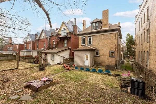 a backyard of a house with fire pit and chairs