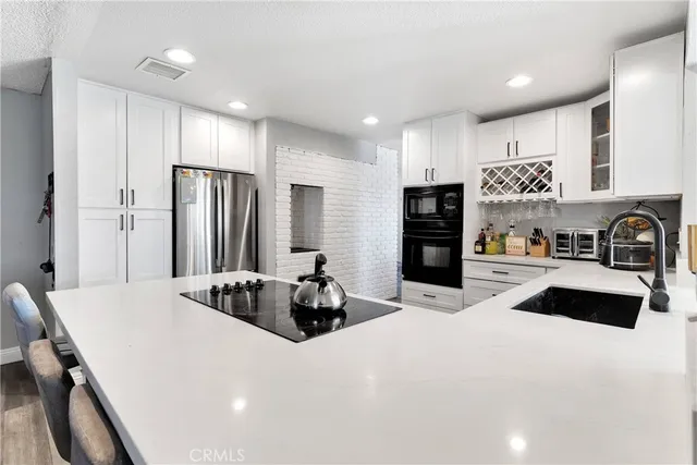 a kitchen with stainless steel appliances a refrigerator sink and stove