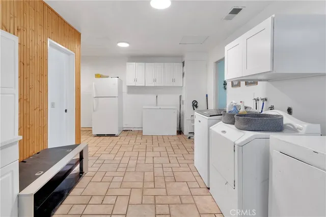 a spacious bedroom with a bed and a chandelier