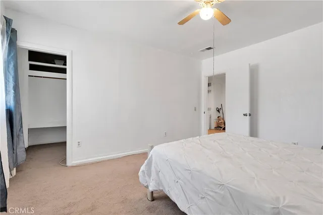 a spacious bedroom with a bed and a television