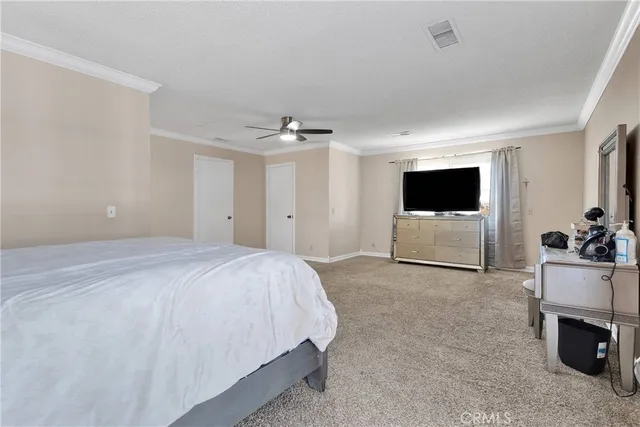 a spacious bedroom with a bed and ceiling fan
