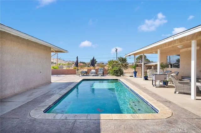a view of a house with swimming pool and sitting area
