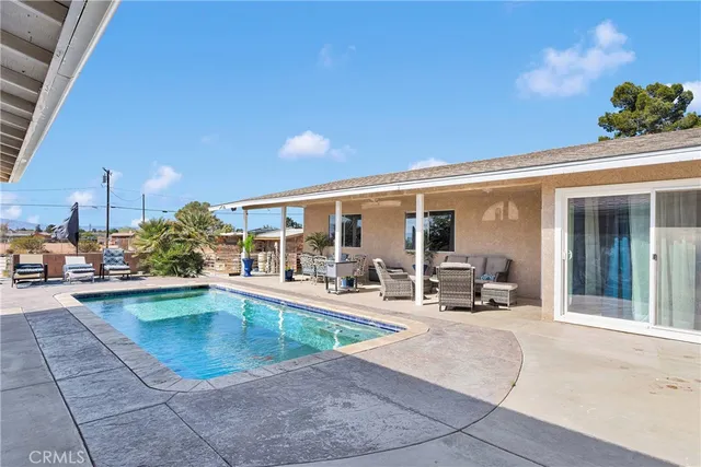 a view of a dining room with furniture one side kitchen view and wooden floor