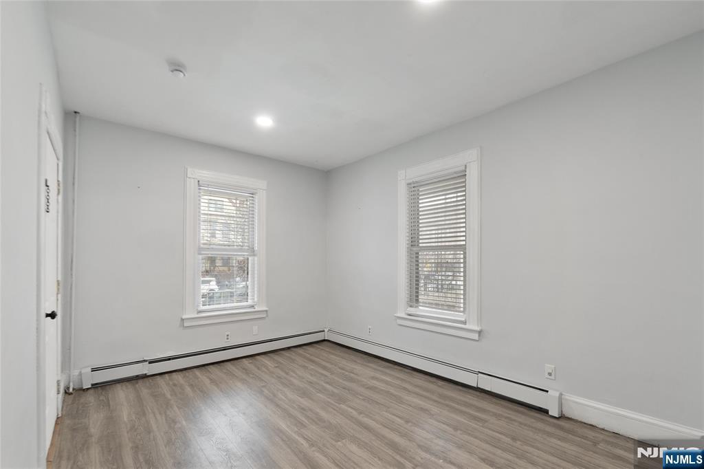 580 Monroe Avenue, Unit 1 Elizabeth, NJ 07201 - Photo 5 of 10 a view of an empty room with wooden floor and a window