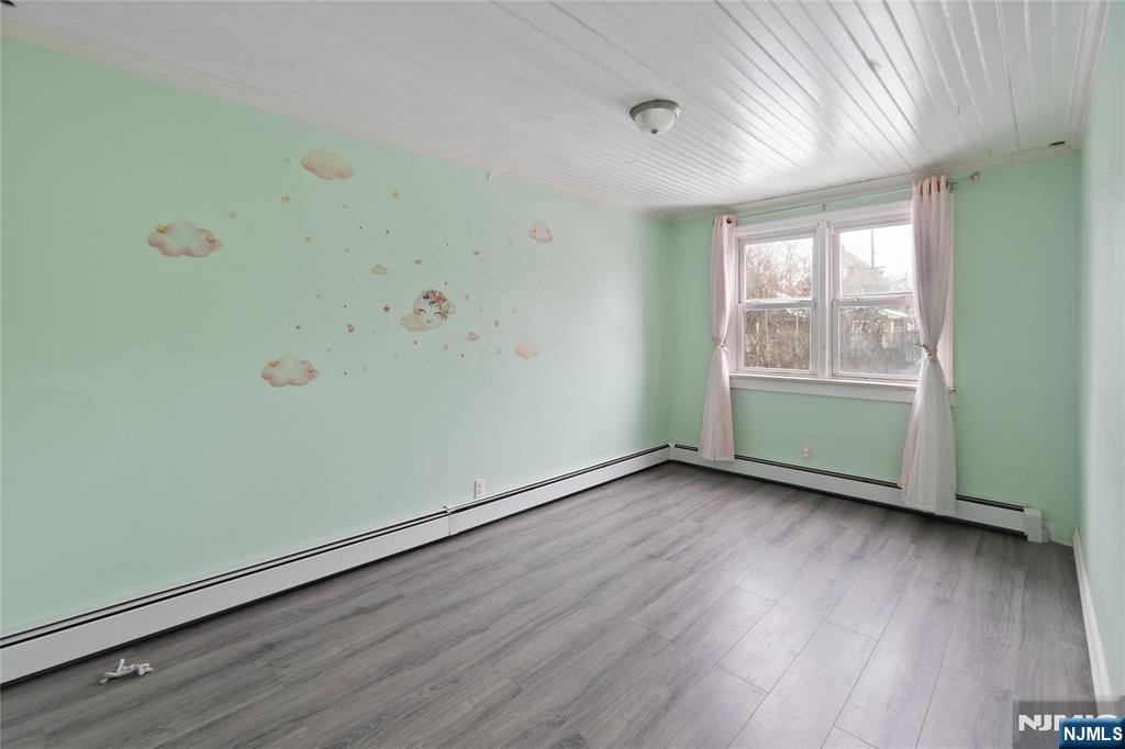 580 Monroe Avenue, Unit 1 Elizabeth, NJ 07201 - Photo 8 of 10 an empty room with wooden floor and windows