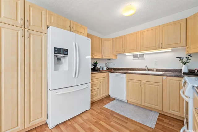 a kitchen with granite countertop white cabinets and white appliances