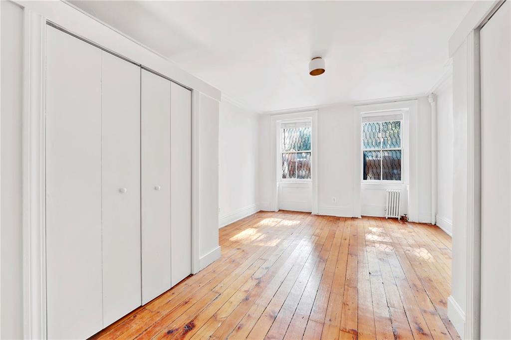 398 Henry Street Brooklyn, NY 11201 - Photo 9 of 14 a view of an empty room with wooden floor and a window