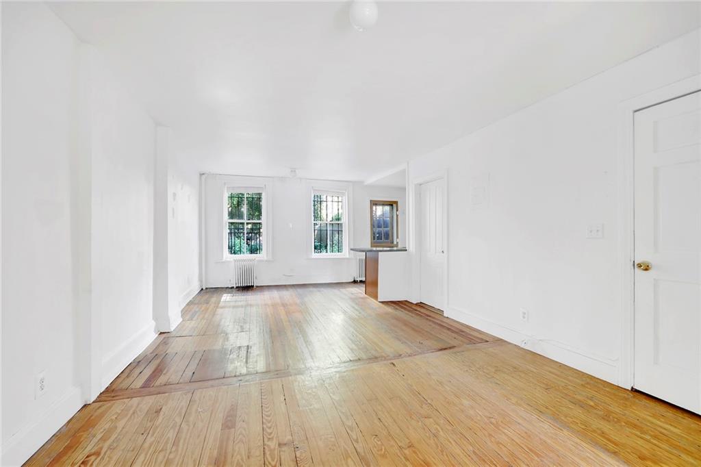 398 Henry Street Brooklyn, NY 11201 - Photo 10 of 14 a view of an empty room with wooden floor and a window