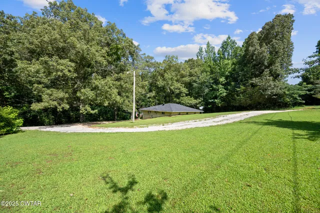 a view of yard with swimming pool and green space