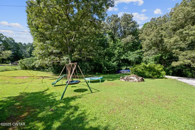 a view of a backyard with a slide and a small yard