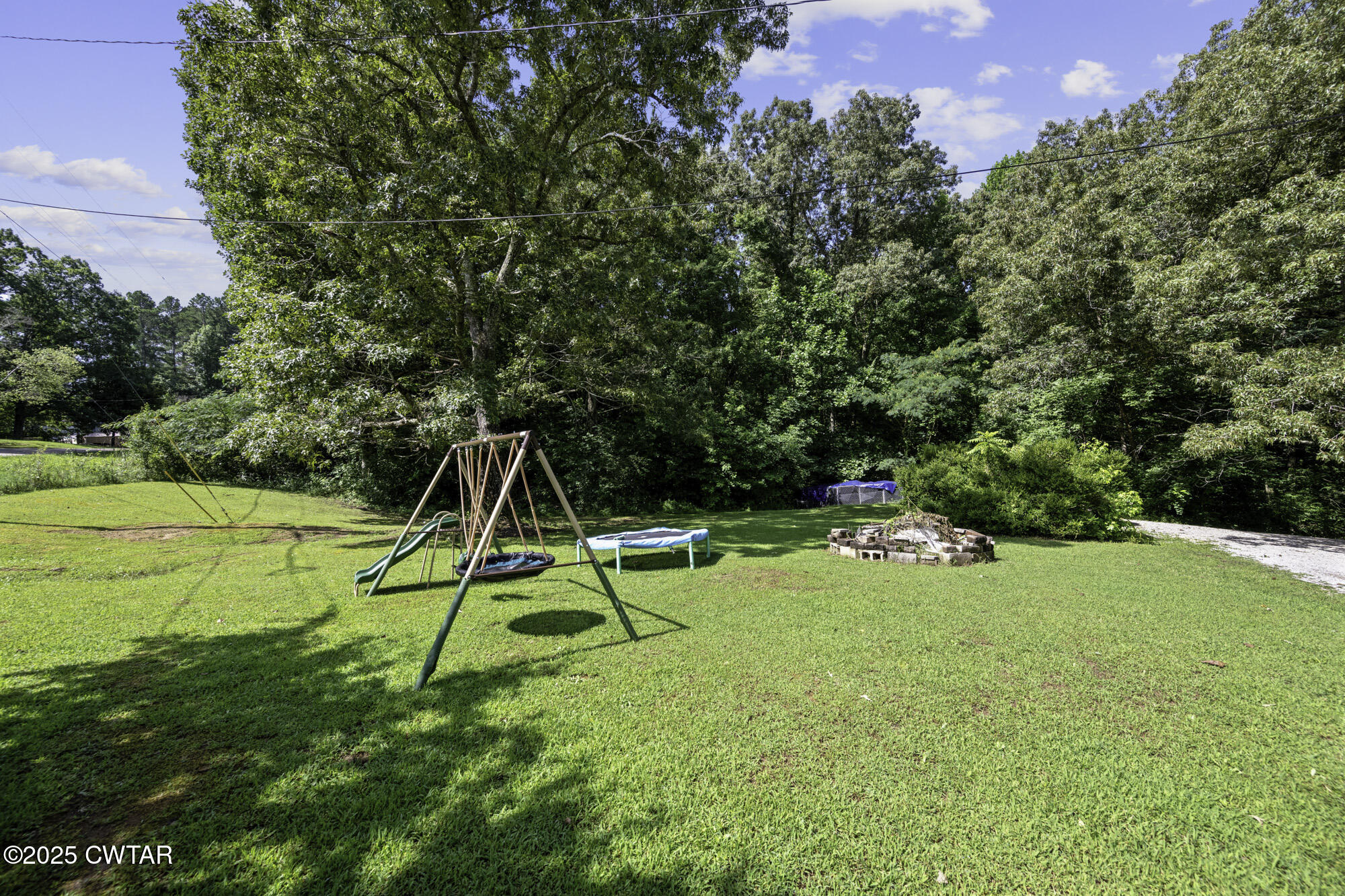 185 Corinth Road Darden, TN 38328 - Photo 3 of 8 a view of a backyard with a slide and a small yard