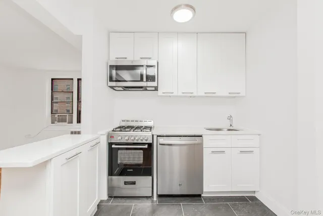 a kitchen with white cabinets and white appliances