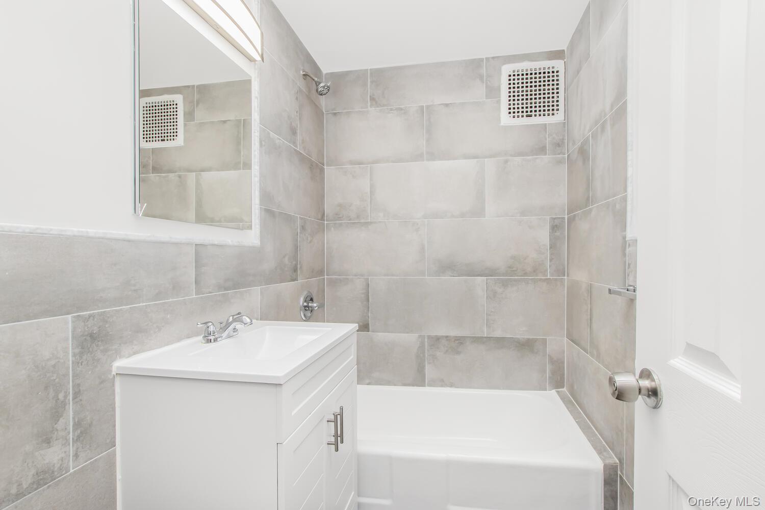 2165 Matthews Avenue, Unit 4B Bronx, NY 10462 - Photo 16 of 16 a bathroom with a sink a mirror and a bathtub