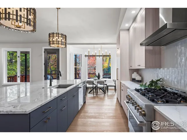 a kitchen with stainless steel appliances granite countertop a stove a sink dishwasher and cabinets with wooden floor