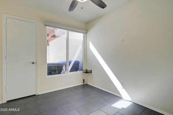 an empty room with a ceiling fan and a window
