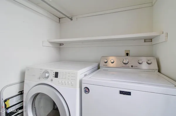 a view of a backyard with a table and chairs under an umbrella
