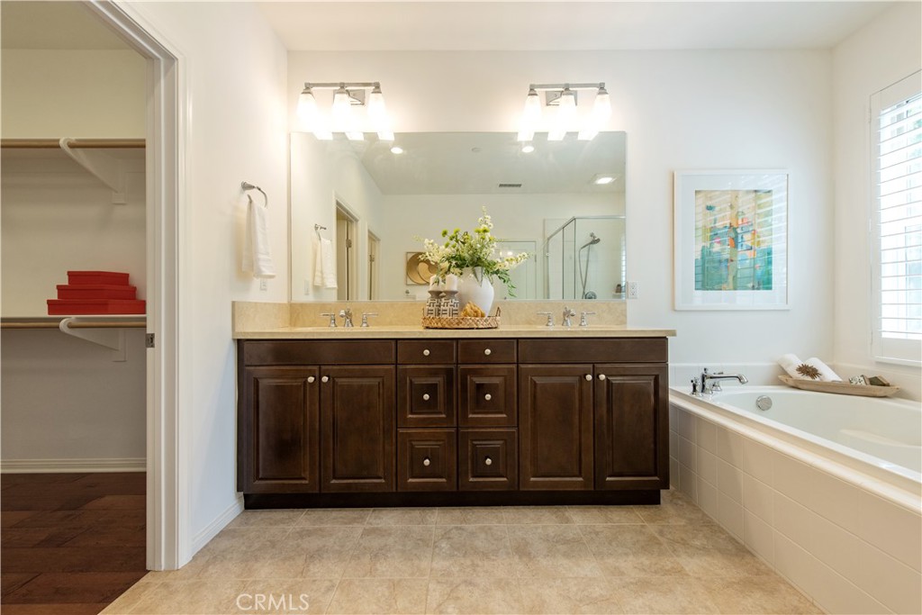 238 Shelbourne Irvine, CA 92620 - Photo 15 of 36 a bathroom with a tub a double vanity sink and a mirror