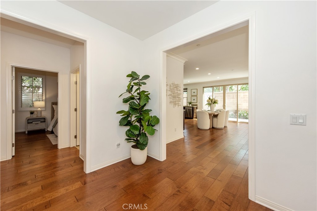 238 Shelbourne Irvine, CA 92620 - Photo 2 of 36 a hallway with wooden floor and a dining room