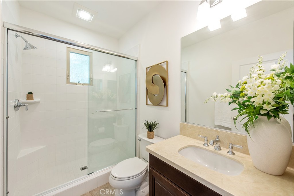238 Shelbourne Irvine, CA 92620 - Photo 23 of 36 a bathroom with a granite countertop sink toilet a large mirror a shower and a bathroom