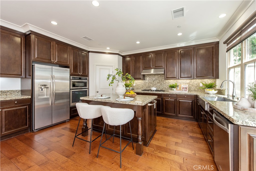 238 Shelbourne Irvine, CA 92620 - Photo 4 of 36 a kitchen with stainless steel appliances granite countertop a stove a sink a refrigerator and chairs