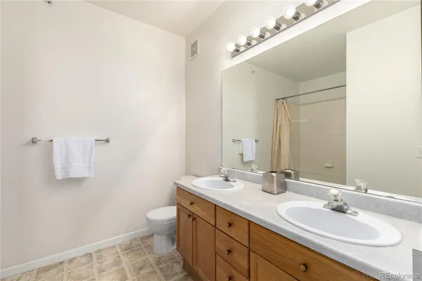 a bathroom with a granite countertop sink a toilet and a mirror
