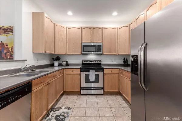 a kitchen with stainless steel appliances granite countertop a stove a sink and a refrigerator