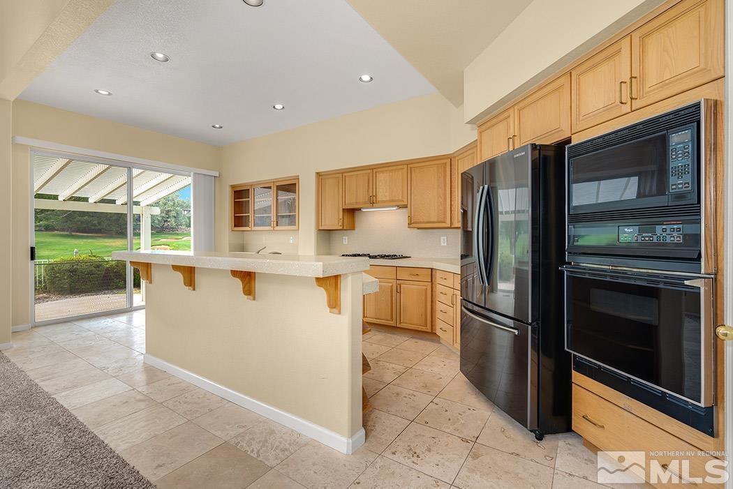 6142 Wycliffe Circle Reno, NV 89519 - Photo 4 of 29 a kitchen with stainless steel appliances granite countertop a refrigerator a stove a sink and a microwave oven with cabinets