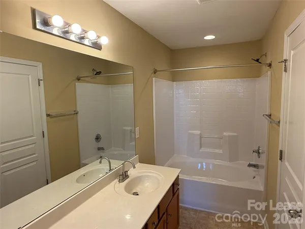 a bathroom with a sink tub shower and a mirror