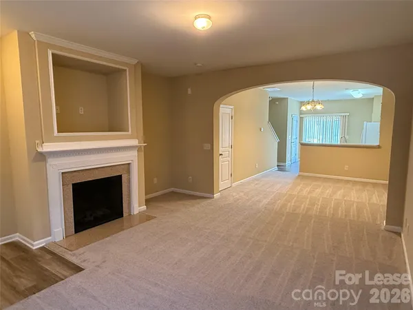 a view of an empty room with window and fire place