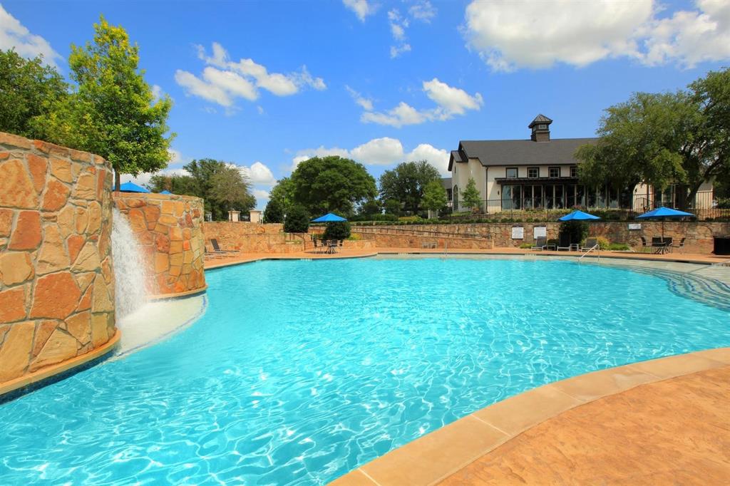 2809 Little Current Court Celina, TX 75009 - Photo 7 of 10 a view of a swimming pool with lawn chairs under an umbrella