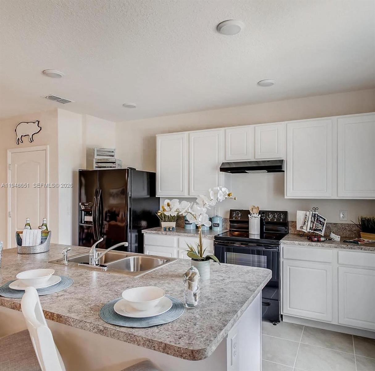 1563 Dawnview Way Kissimmee, FL 34744 - Photo 2 of 14 a kitchen with kitchen island granite countertop a sink a stove and cabinets
