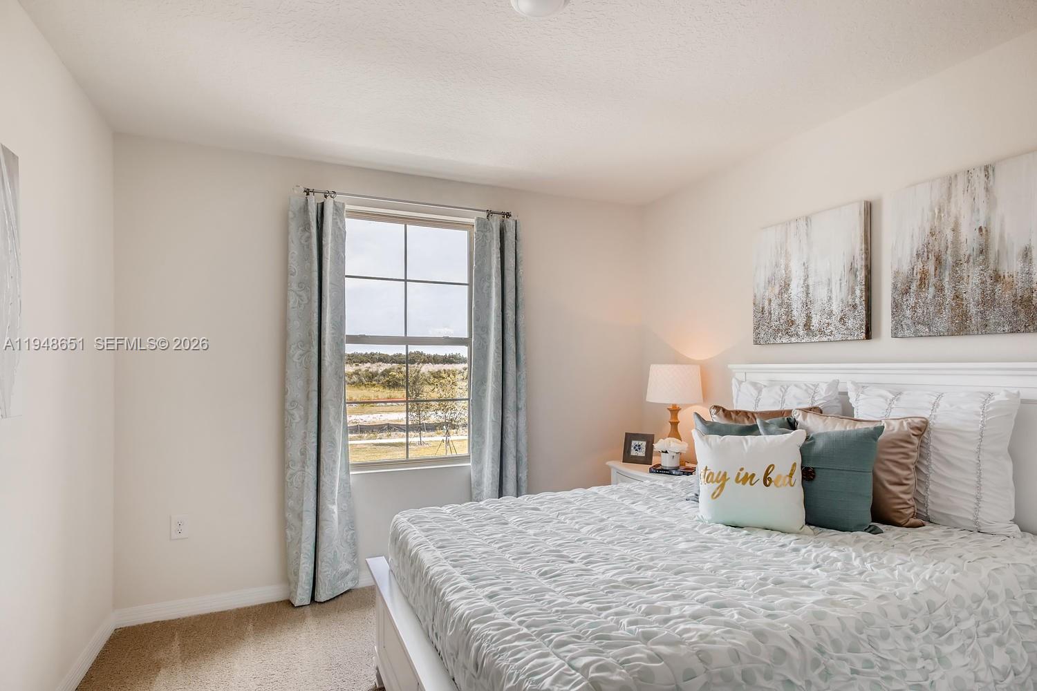 1563 Dawnview Way Kissimmee, FL 34744 - Photo 5 of 14 a large bed sitting in a bedroom next to a window