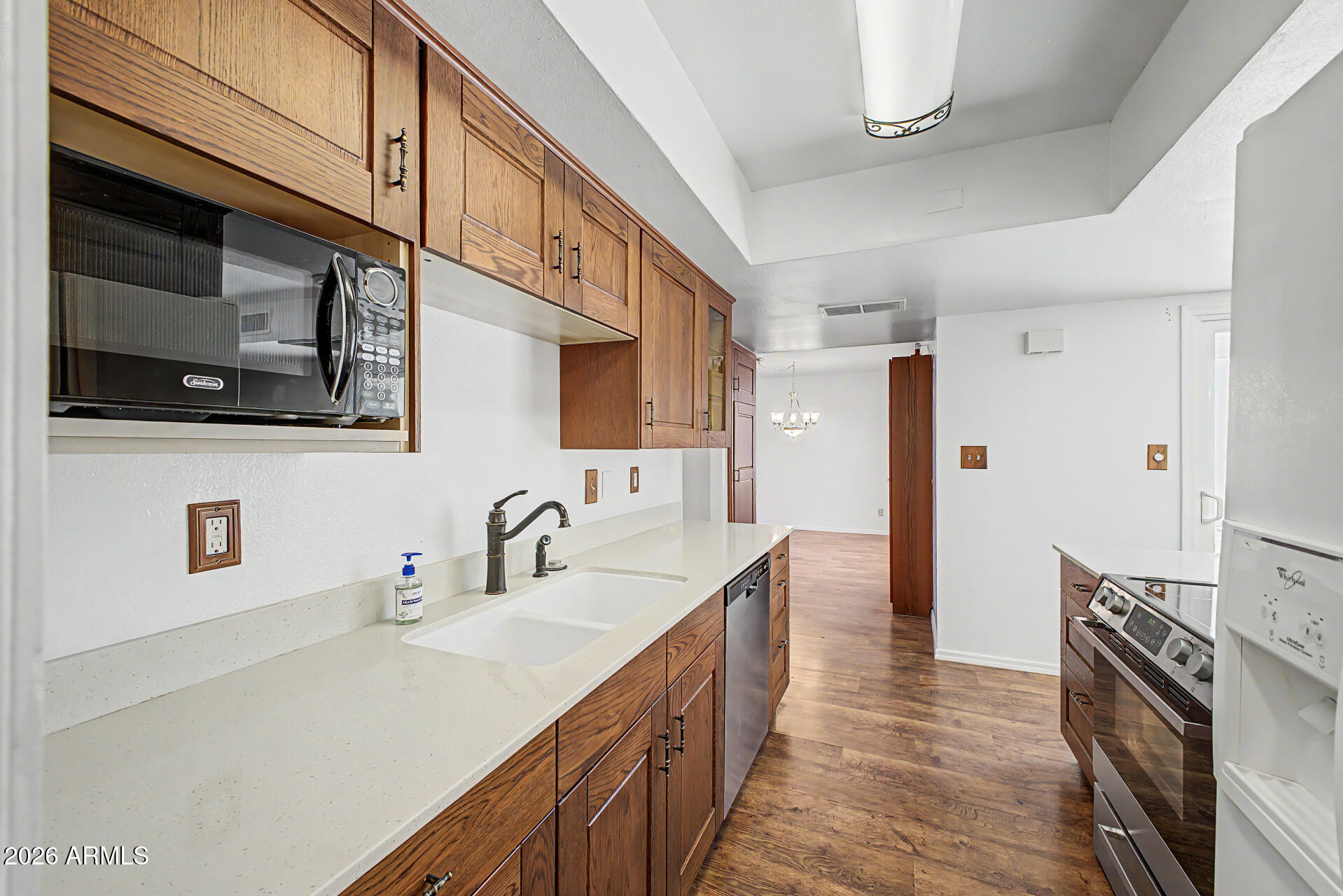 5873 East Thomas Road Scottsdale, AZ 85251 - Photo 10 of 30 a kitchen with stainless steel appliances sink a microwave and cabinets