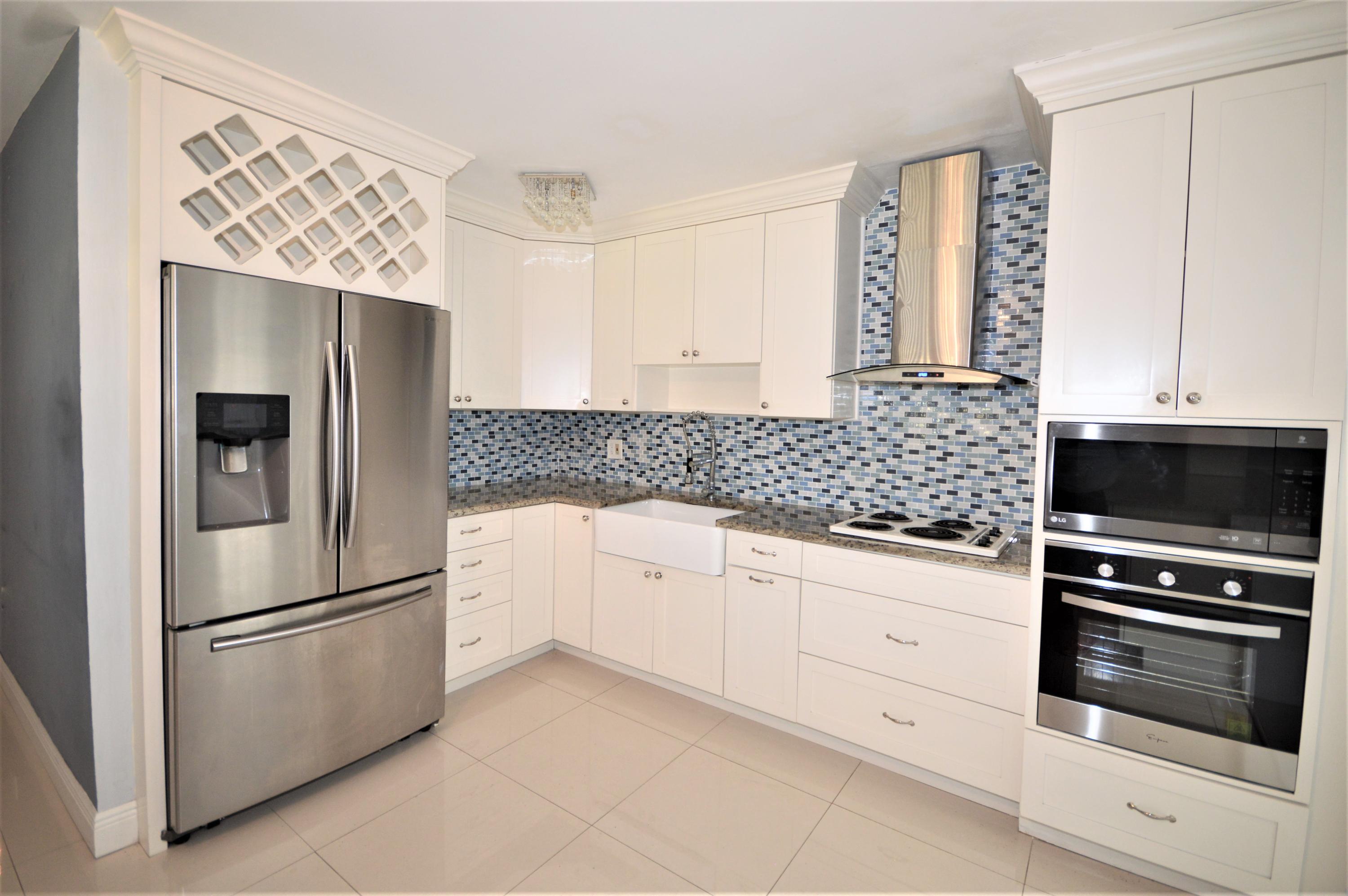 4092 Rochester Street Palm Beach Gardens, FL 33410 - Photo 11 of 28 a kitchen with stainless steel appliances a refrigerator sink and stove top oven