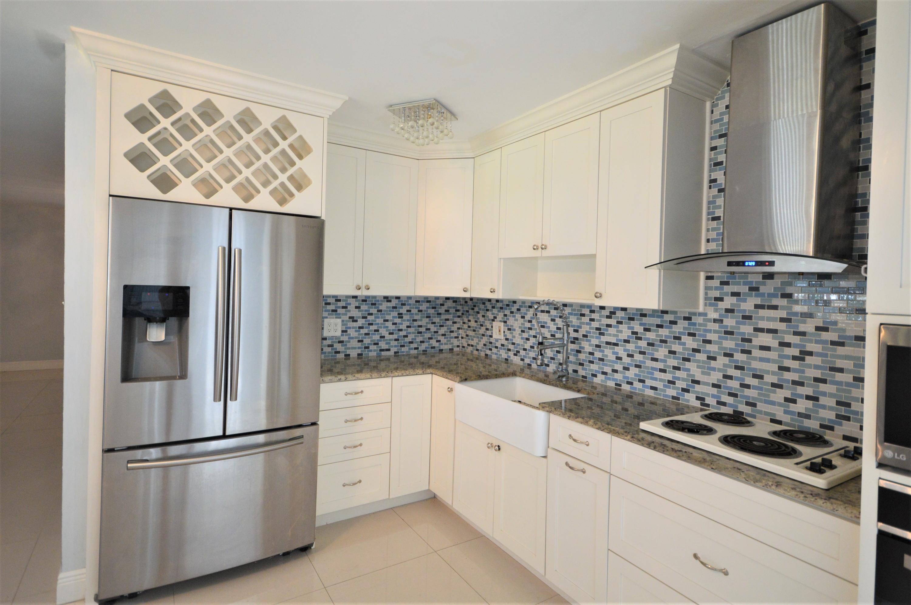 4092 Rochester Street Palm Beach Gardens, FL 33410 - Photo 12 of 28 a kitchen with a refrigerator and a sink