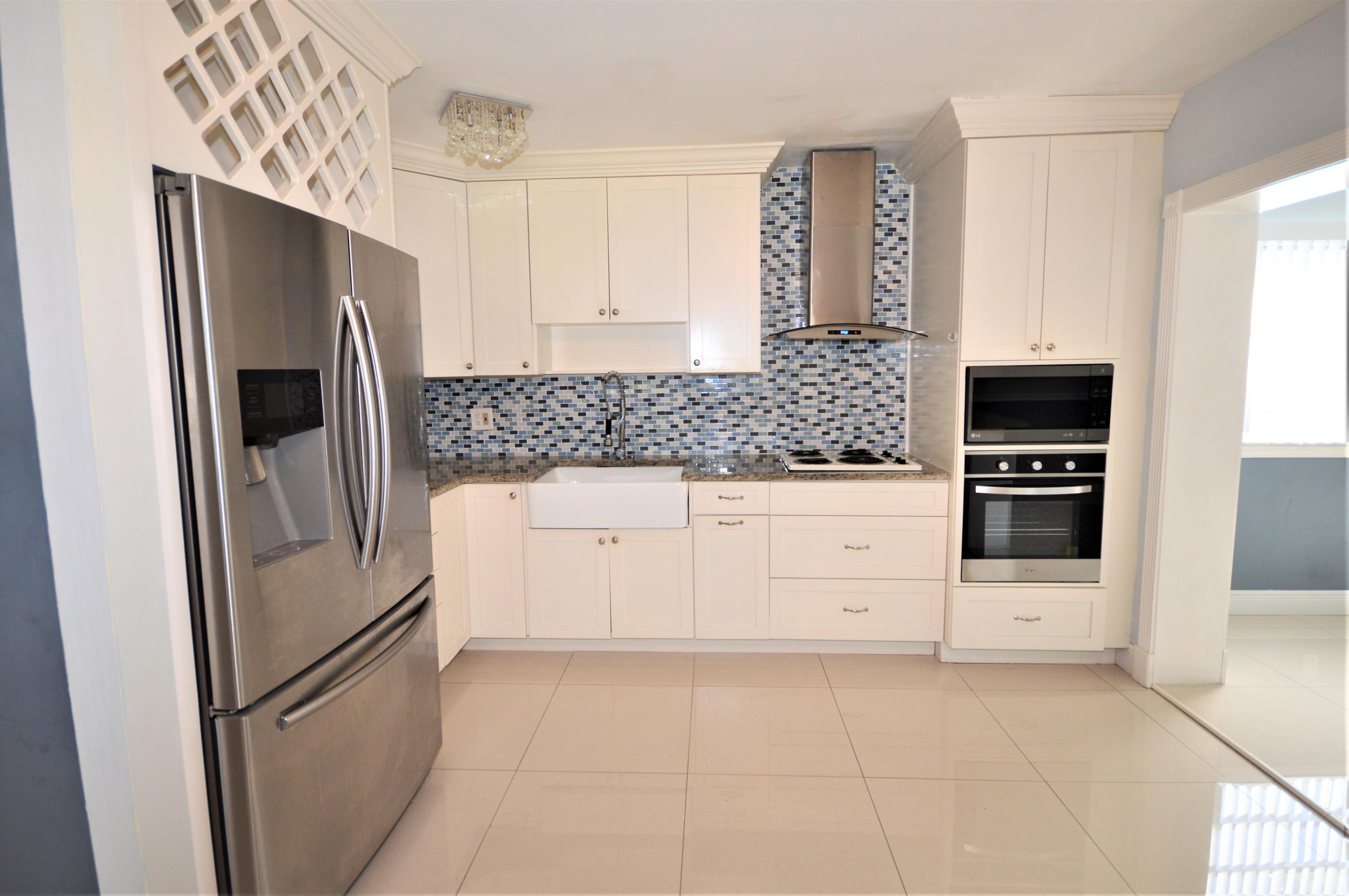 4092 Rochester Street Palm Beach Gardens, FL 33410 - Photo 14 of 28 a kitchen with stainless steel appliances cabinets and a refrigerator
