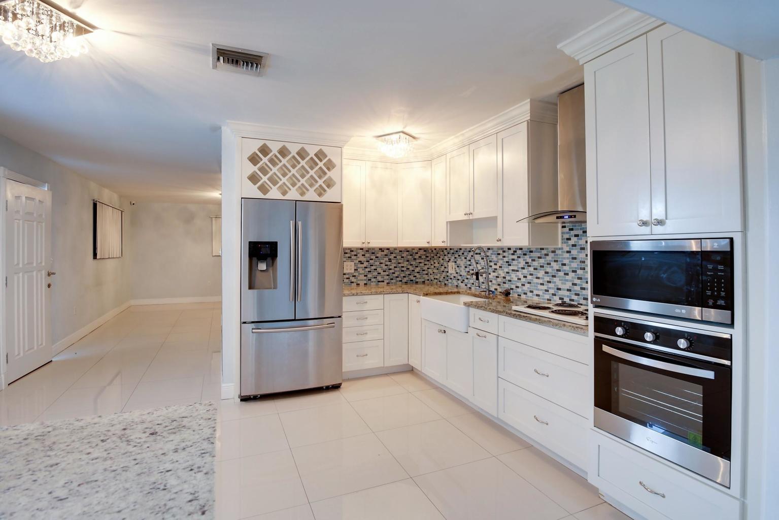 4092 Rochester Street Palm Beach Gardens, FL 33410 - Photo 16 of 28 a kitchen with a refrigerator and a stove top oven