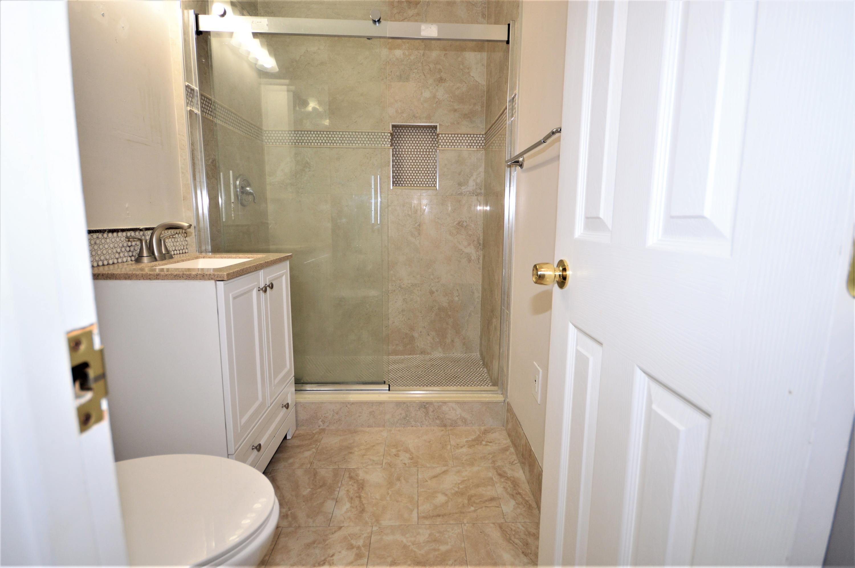 4092 Rochester Street Palm Beach Gardens, FL 33410 - Photo 23 of 28 a bathroom with a sink a toilet and shower