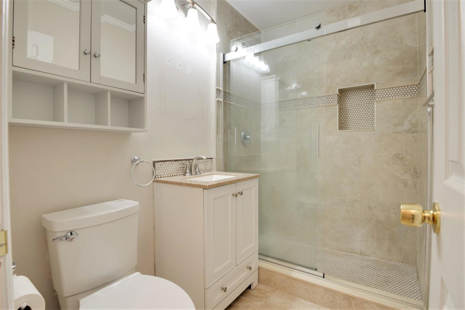 4092 Rochester Street Palm Beach Gardens, FL 33410 - Photo 24 of 28 a bathroom with a toilet sink and shower