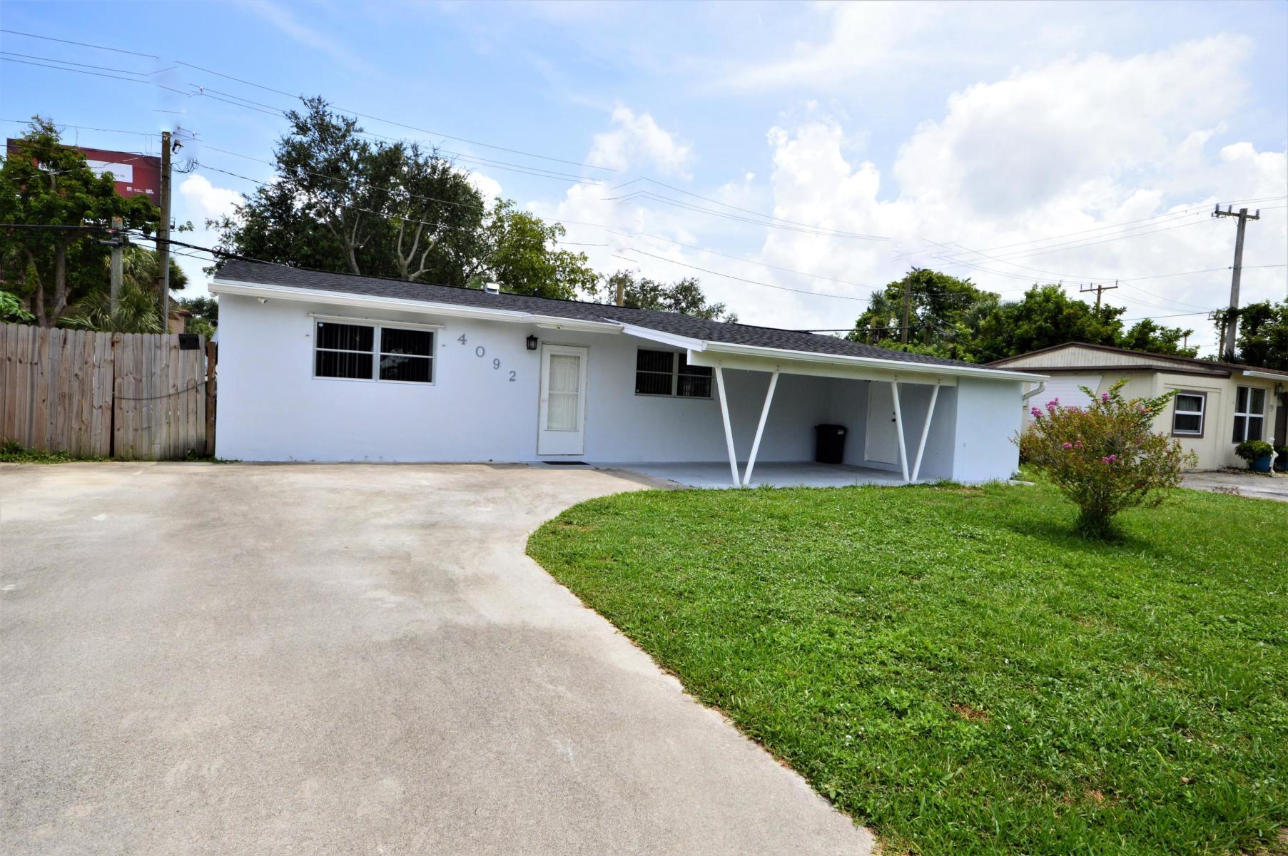 4092 Rochester Street Palm Beach Gardens, FL 33410 - Photo 4 of 28 a house that is sitting in the grass