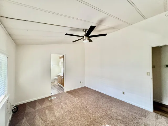 an empty room with a ceiling fan and a window