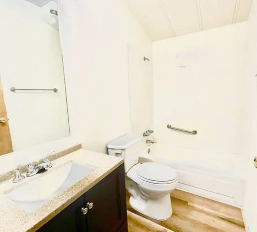 a bathroom with a granite countertop sink a toilet and a mirror