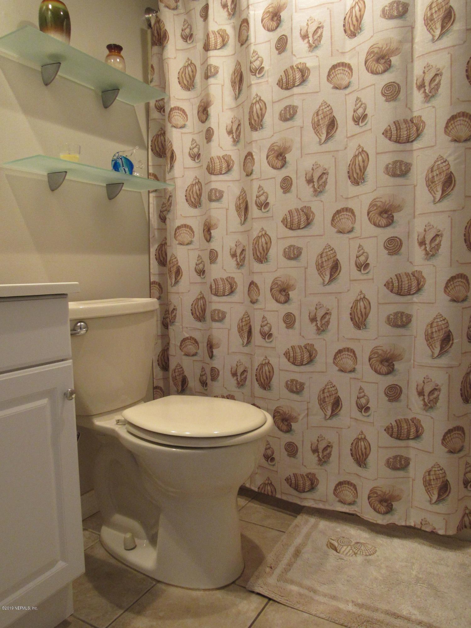 7175 South A1a Street, Unit B212 St. Augustine, FL 32080 - Photo 15 of 29 a white toilet sitting next to a shower curtain